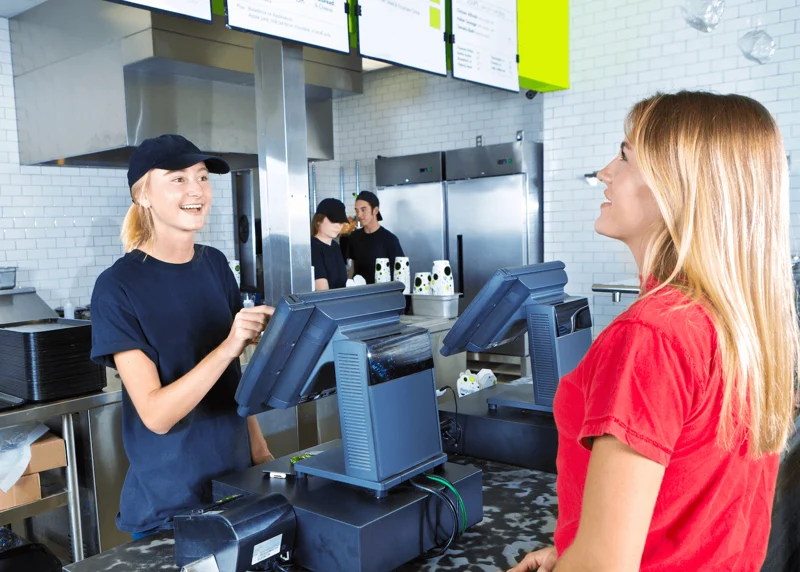 Employee taking order using a fast food pos system software